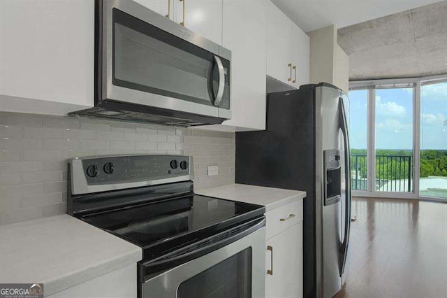 361 17th St Unit 910, Atlanta, GA 30363 - kitchen featuring appliances with stainless steel finishes, white cabinetry, light countertops, tasteful backsplash, and floor to ceiling windows