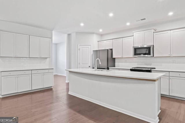 400 Paulownia Cir, Mcdonough, GA 30253 - kitchen featuring stainless steel appliances, a center island with sink, backsplash, light countertops, and recessed lighting