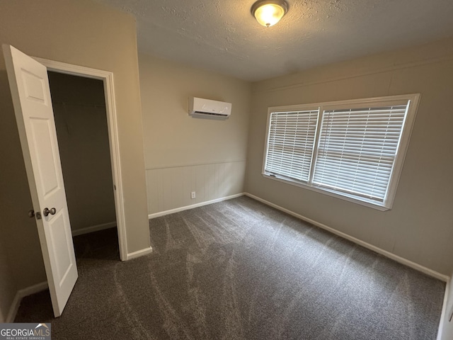 4329 Parkview Dr, Lithia Springs, GA 30122 - unfurnished bedroom with a textured ceiling, dark carpet, a wall mounted air conditioner, and a closet