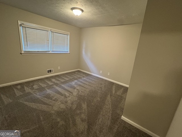 4329 Parkview Dr, Lithia Springs, GA 30122 - spare room featuring a textured ceiling and dark colored carpet