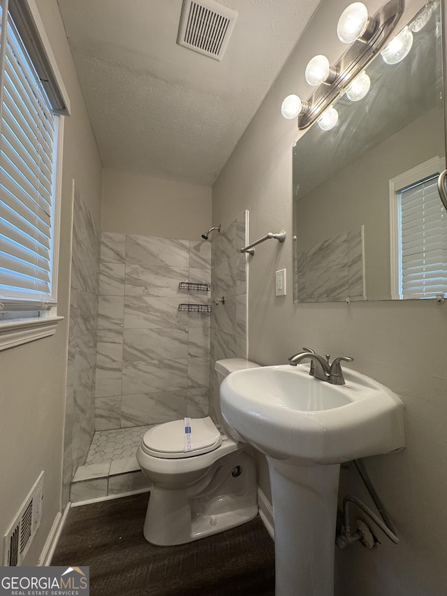 4329 Parkview Dr, Lithia Springs, GA 30122 - bathroom featuring a tile shower, a textured ceiling, wood finished floors, and a chandelier