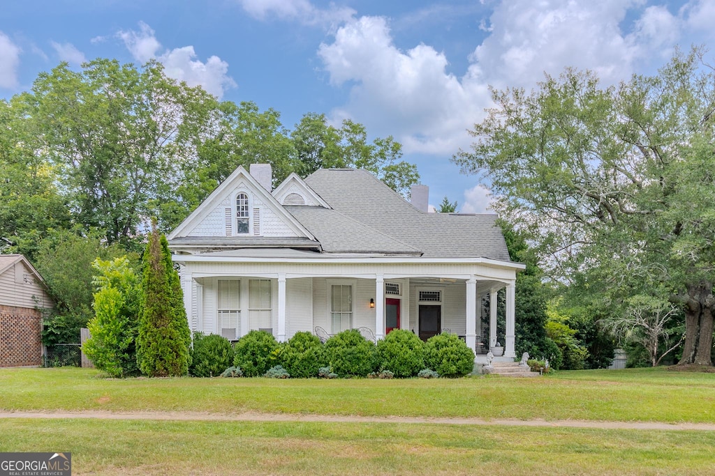 5 W Oak St, Luthersville, GA 30251 - view of front facade featuring covered porch, a chimney, a front lawn, and roof with shingles