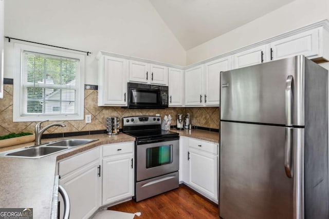 2140 Hurt Rd SW, Marietta, GA 30008 - kitchen featuring appliances with stainless steel finishes, lofted ceiling, white cabinetry, tasteful backsplash, and dark wood-style floors