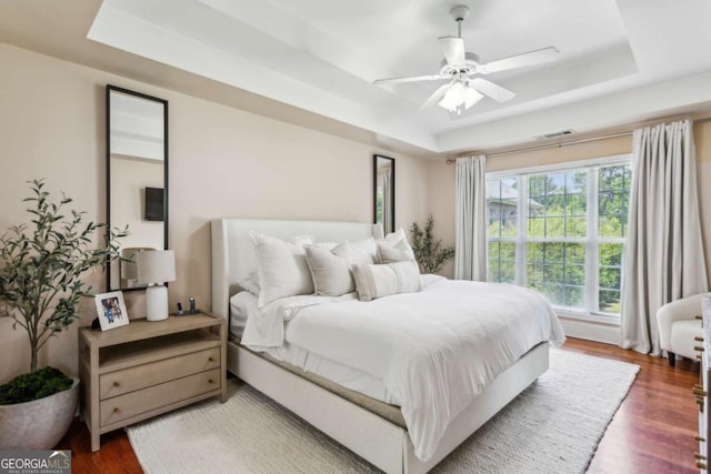 2140 Hurt Rd SW, Marietta, GA 30008 - bedroom with a tray ceiling, wood finished floors, and ceiling fan