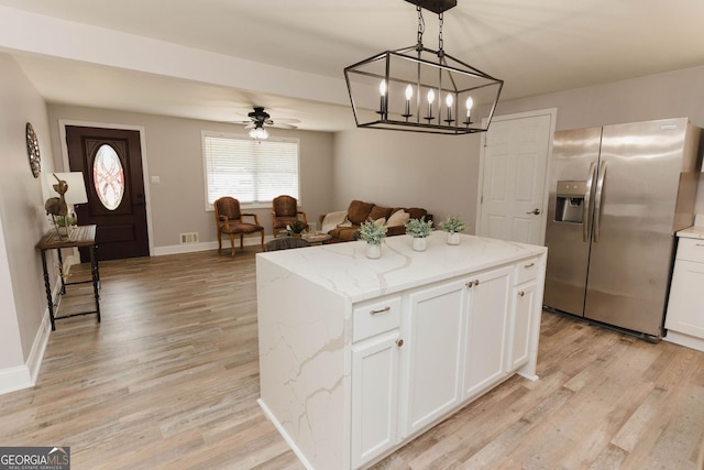 6914 N Baggett Rd, Douglasville, GA 30134 - kitchen featuring stainless steel fridge with ice dispenser, white cabinetry, light wood-type flooring, a center island, and ceiling fan