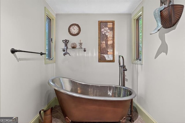 686 Hillwood Ct, Dacula, GA 30019 - bathroom featuring a soaking tub and baseboards