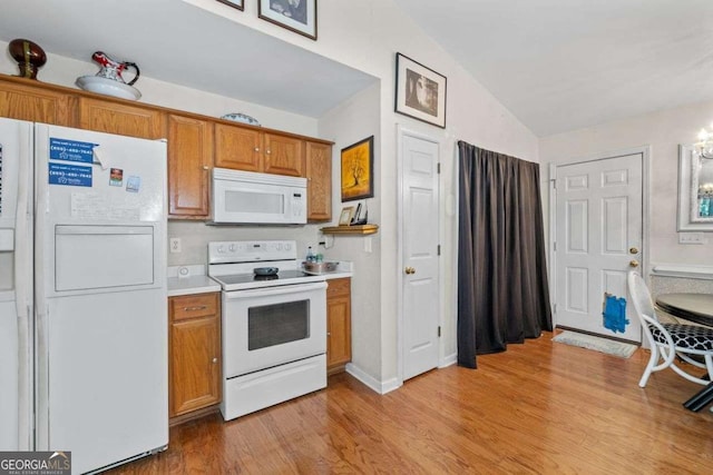 2030 Buford Dam Rd, Buford, GA 30518 - kitchen with white appliances, light wood-style floors, vaulted ceiling, light countertops, and brown cabinetry