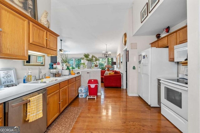 2030 Buford Dam Rd, Buford, GA 30518 - kitchen with white appliances, light countertops, a chandelier, light wood finished floors, and brown cabinetry