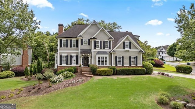 295 Sagamore Cv NW, Sugar Hill, GA 30518 - view of front facade with a front lawn and a chimney