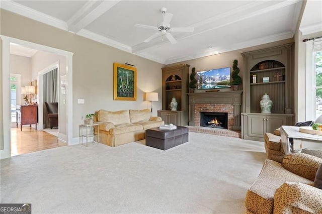 295 Sagamore Cv NW, Sugar Hill, GA 30518 - carpeted living area with a ceiling fan, a fireplace, beam ceiling, and ornamental molding