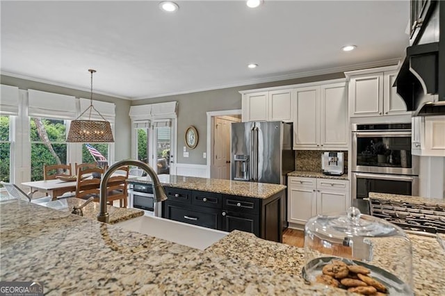 295 Sagamore Cv NW, Sugar Hill, GA 30518 - kitchen with stainless steel appliances, crown molding, white cabinetry, light stone counters, and pendant lighting