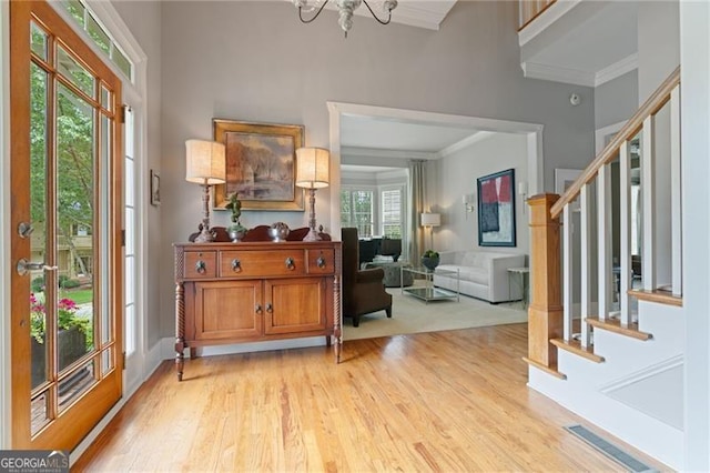 295 Sagamore Cv NW, Sugar Hill, GA 30518 - foyer with ornamental molding, stairs, light wood-style flooring, and a chandelier