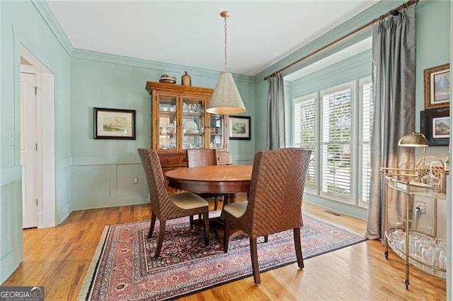 295 Sagamore Cv NW, Sugar Hill, GA 30518 - dining space featuring wood finished floors, crown molding, a decorative wall, and a wainscoted wall
