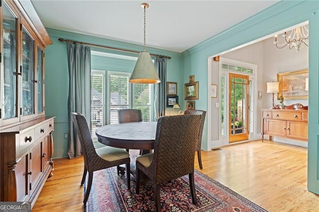 295 Sagamore Cv NW, Sugar Hill, GA 30518 - dining room with a chandelier, light wood-style flooring, and ornamental molding