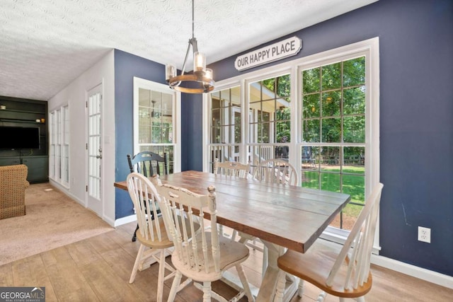 5055 Southland Dr, Woodstock, GA 30188 - dining area featuring a chandelier, light wood finished floors, healthy amount of natural light, a textured ceiling, and french doors
