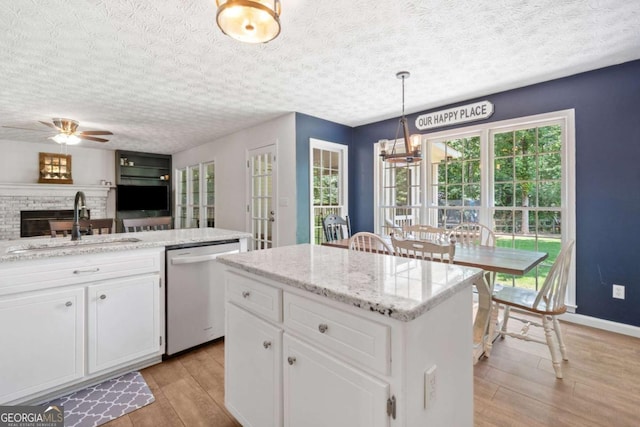 5055 Southland Dr, Woodstock, GA 30188 - kitchen with dishwasher, light wood-type flooring, a center island, a textured ceiling, and white cabinets
