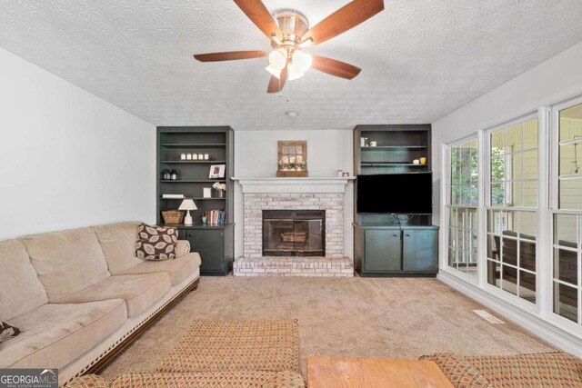 5055 Southland Dr, Woodstock, GA 30188 - carpeted living room featuring a textured ceiling, a ceiling fan, a brick fireplace, and built in shelves