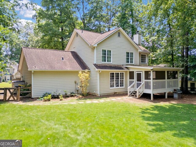 5055 Southland Dr, Woodstock, GA 30188 - back of house with a chimney, a sunroom, and a shingled roof