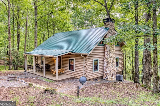 371 Abbott Top Rd, Ellijay, GA 30540 - view of front of home featuring log exterior, a metal roof, a chimney, a patio area, and a forest view