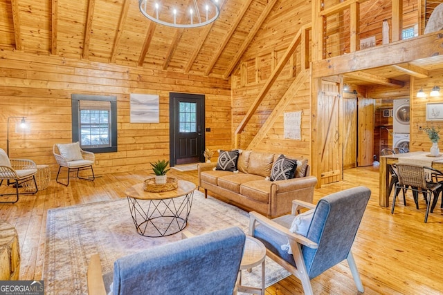 371 Abbott Top Rd, Ellijay, GA 30540 - living area featuring stacked washing machine and dryer, high vaulted ceiling, wooden walls, hardwood / wood-style flooring, and a wood ceiling with exposed beams