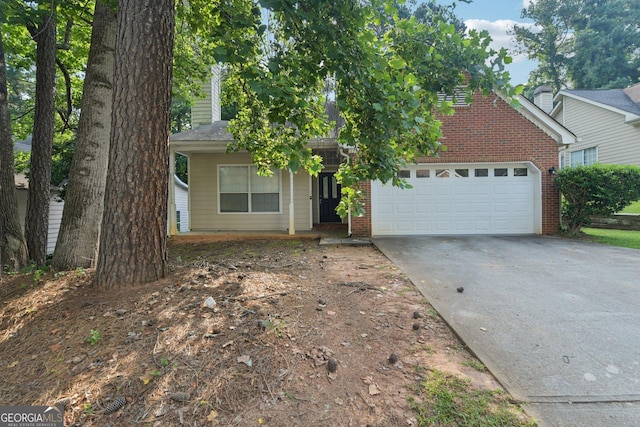 686 Shore Ln, Lithonia, GA 30058 - obstructed view of property with concrete driveway, brick siding, an attached garage, and a chimney