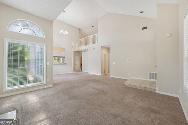 686 Shore Ln, Lithonia, GA 30058 - unfurnished living room with high vaulted ceiling, carpet flooring, and a chandelier
