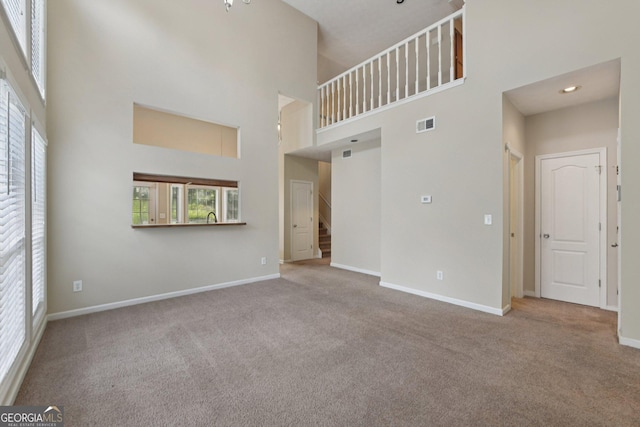 686 Shore Ln, Lithonia, GA 30058 - unfurnished living room featuring a towering ceiling, carpet floors, and stairway