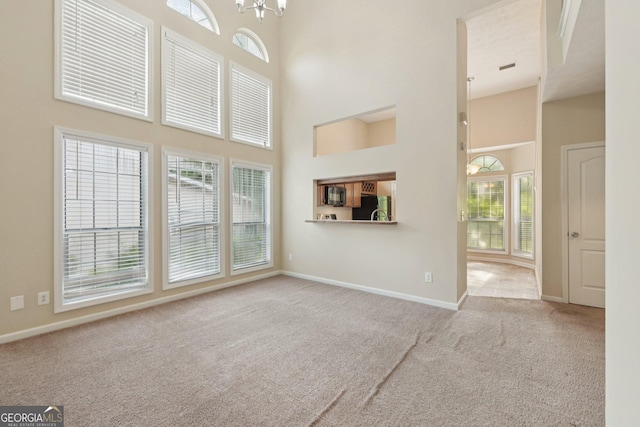 686 Shore Ln, Lithonia, GA 30058 - unfurnished living room with a high ceiling, carpet, and a chandelier