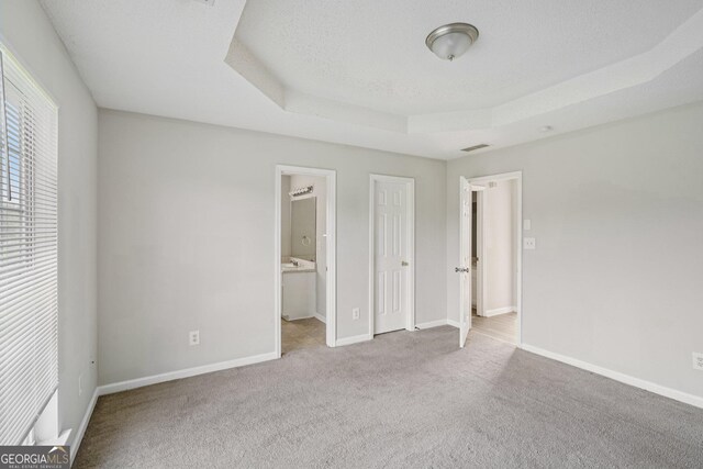 4738 Golod Way, Lithonia, GA 30038 - unfurnished bedroom featuring a tray ceiling, carpet, and ensuite bathroom