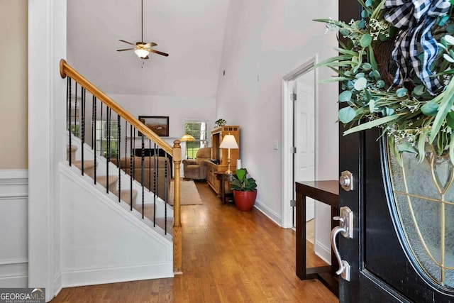7198 Golfside Dr SE, Covington, GA 30014 - foyer entrance with wood finished floors, ceiling fan, stairs, and a towering ceiling