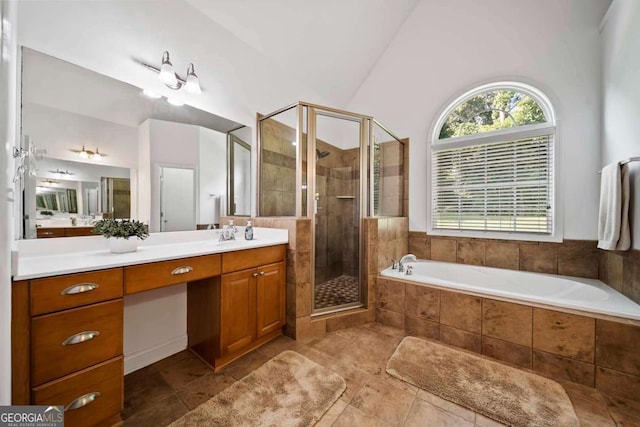 7198 Golfside Dr SE, Covington, GA 30014 - bathroom featuring vanity, a bath, a stall shower, vaulted ceiling, and tile patterned flooring