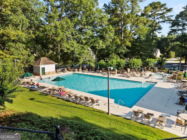 7198 Golfside Dr SE, Covington, GA 30014 - community pool featuring a yard, a patio area, and view of wooded area