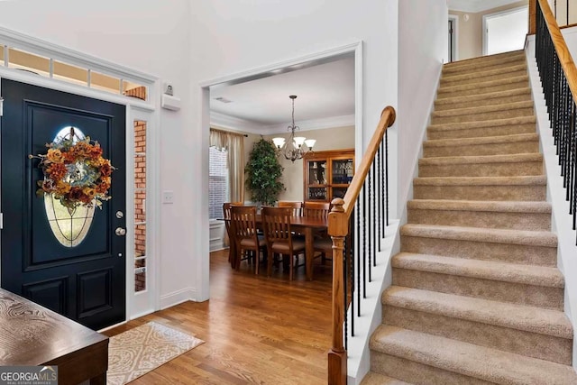 7198 Golfside Dr SE, Covington, GA 30014 - entryway featuring stairs, light wood finished floors, a chandelier, and crown molding