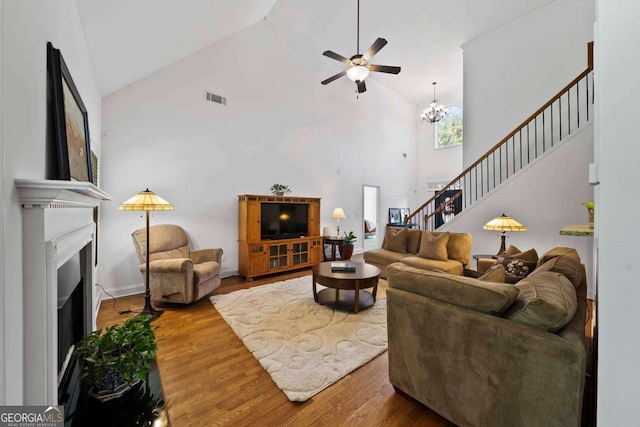 7198 Golfside Dr SE, Covington, GA 30014 - living area with high vaulted ceiling, a ceiling fan, wood finished floors, stairway, and a fireplace