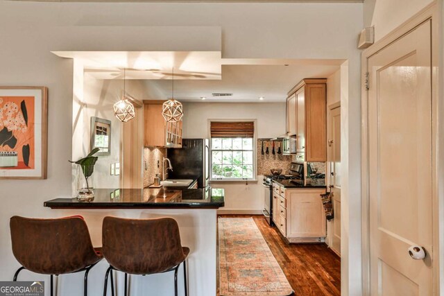 55 Delmont Dr NE Unit C3, Atlanta, GA 30305 - kitchen featuring stainless steel appliances, a peninsula, dark countertops, and tasteful backsplash