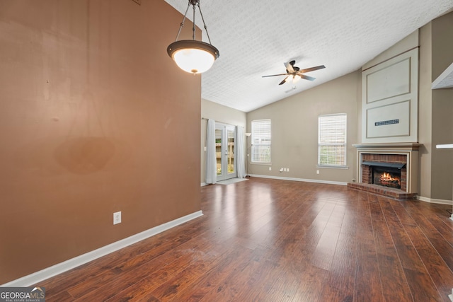 377 Avian Forest Dr, Stockbridge, GA 30281 - unfurnished living room with ceiling fan, vaulted ceiling, wood-type flooring, and a fireplace