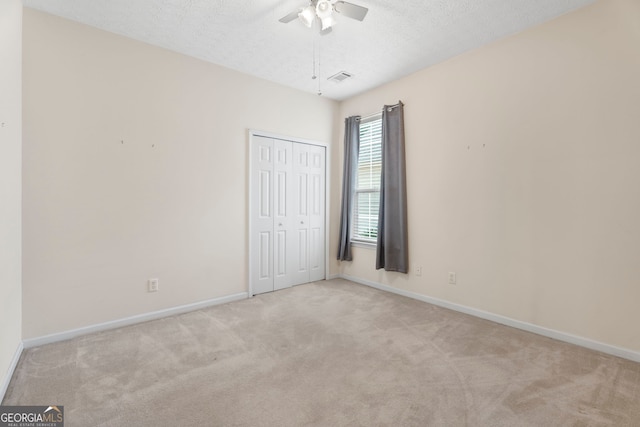 377 Avian Forest Dr, Stockbridge, GA 30281 - unfurnished bedroom with carpet, a closet, a textured ceiling, and a ceiling fan