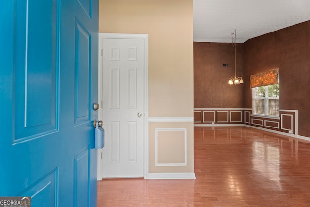 377 Avian Forest Dr, Stockbridge, GA 30281 - foyer entrance with a chandelier, a decorative wall, wood finished floors, and a wainscoted wall