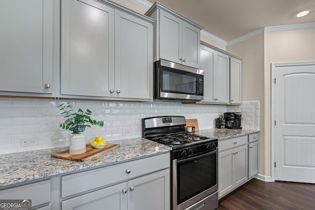 5804 Screech Owl Dr, Flowery Branch, GA 30542 - kitchen featuring stainless steel appliances, ornamental molding, dark wood-style flooring, and light stone counters