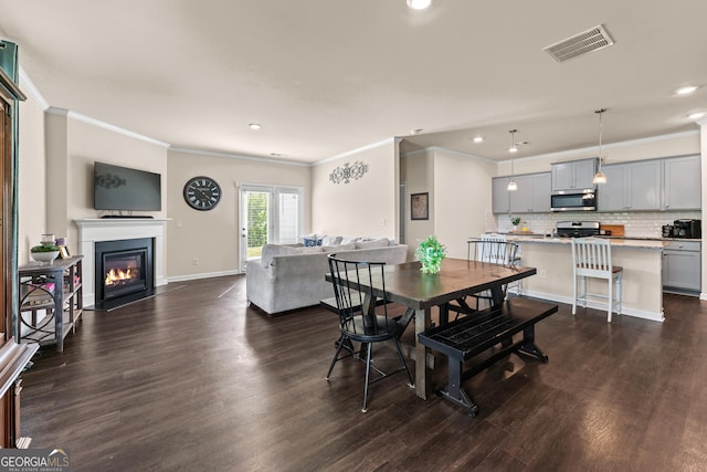 5804 Screech Owl Dr, Flowery Branch, GA 30542 - dining area with ornamental molding, recessed lighting, dark wood-style flooring, and a fireplace with flush hearth