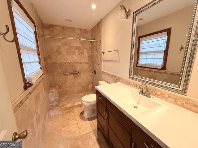 601 Clubland Cir SE, Conyers, GA 30094 - bathroom featuring vanity, tiled shower, tile walls, a wainscoted wall, and recessed lighting