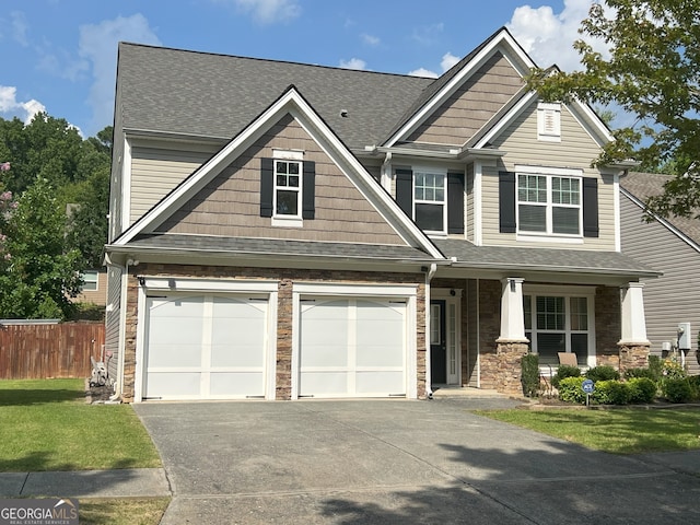 2481 Southhaven Ln, Buford, GA 30519 - craftsman-style house with a porch, concrete driveway, a shingled roof, stone siding, and a garage