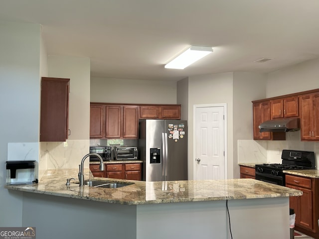 2481 Southhaven Ln, Buford, GA 30519 - kitchen featuring stainless steel fridge, gas stove, under cabinet range hood, backsplash, and light stone countertops
