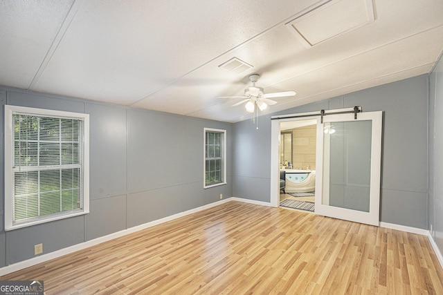 340 Loblolly Rdg, Locust Grove, GA 30248 - unfurnished room with wood finished floors, a barn door, lofted ceiling, and a ceiling fan