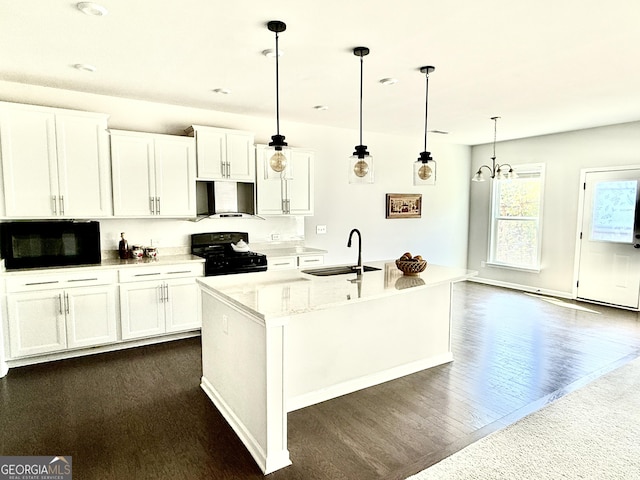 5599 Wheeler Ridge Rd, Auburn, GA 30011 - kitchen with stove, wall chimney range hood, white cabinets, dark wood-style flooring, and decorative light fixtures