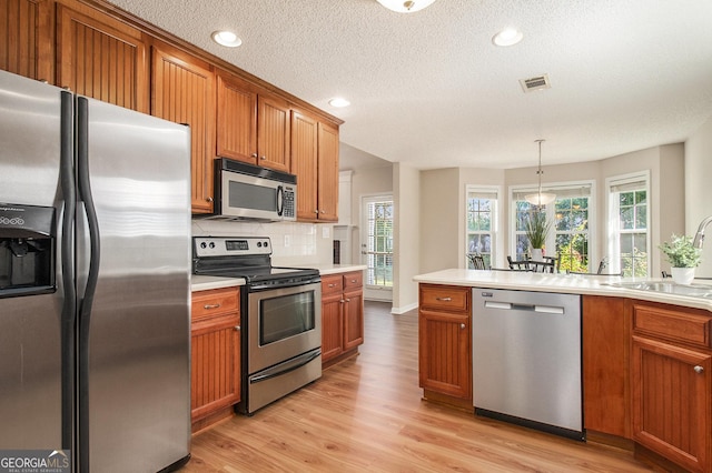 286 Prominent Loop, Mcdonough, GA 30253 - kitchen with stainless steel appliances, brown cabinetry, light countertops, tasteful backsplash, and a textured ceiling