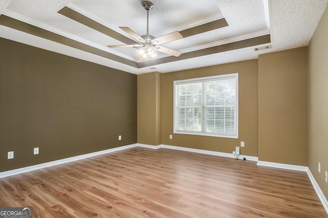 286 Prominent Loop, Mcdonough, GA 30253 - spare room featuring a textured ceiling, a raised ceiling, crown molding, light wood-style flooring, and ceiling fan