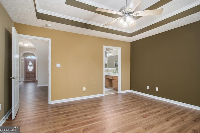 286 Prominent Loop, Mcdonough, GA 30253 - empty room featuring light wood finished floors, a raised ceiling, ceiling fan, crown molding, and arched walkways