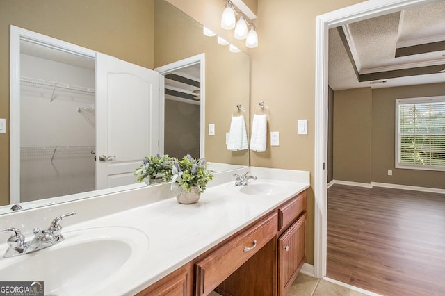 286 Prominent Loop, Mcdonough, GA 30253 - full bathroom featuring double vanity, a textured ceiling, wood finished floors, a spacious closet, and a raised ceiling