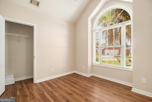 286 Prominent Loop, Mcdonough, GA 30253 - unfurnished bedroom with multiple windows, wood finished floors, vaulted ceiling, and a closet